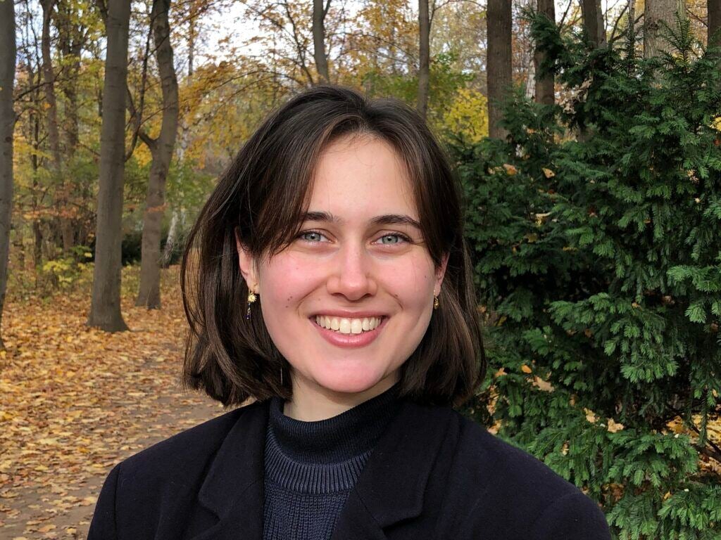Photo of Mira, standing in a forest.